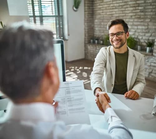 A recruiter and hiring manager shaking hands after a successful Salesforce placement